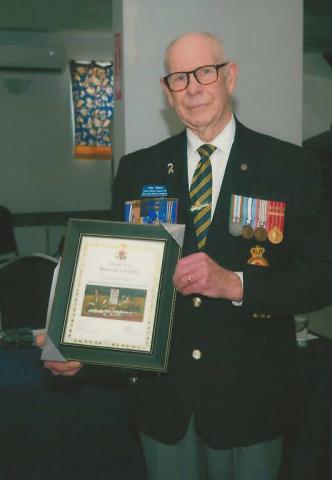 Comrade John Gibson with a certificate that thanks Mannette's Nursery for supporting the Cenotaph gardens